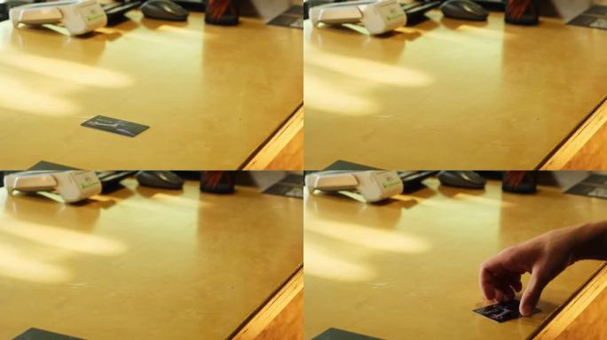 一个人把黑色的体育俱乐部会员卡放在前台的桌子上