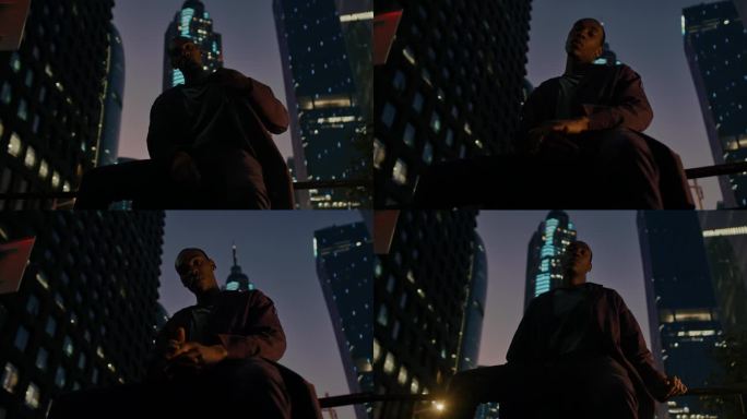 非洲裔美国模特坐在智能城市的镜头前，背景是夜晚照亮的现代摩天大楼