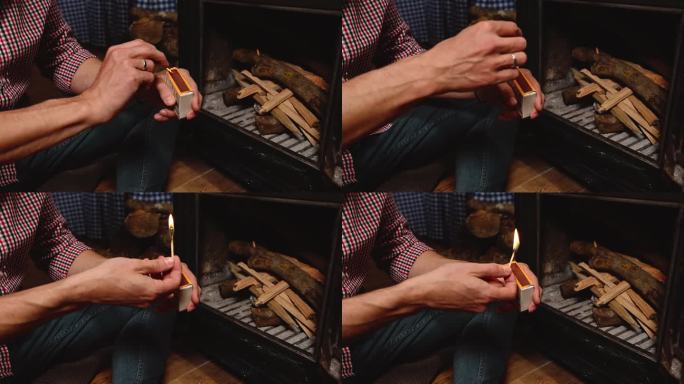 特写:一名男子点燃火柴，在一个旧的铸铁木取暖炉里生火。