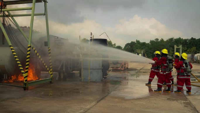 一个由不同年龄的男女组成的消防训练队配备了红色的安全服、安全帽和氧气罐。