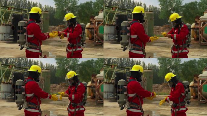 一个由不同年龄的男女组成的消防训练队配备了红色的安全服、安全帽和氧气罐。