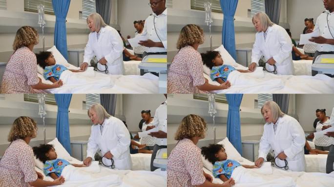 资深女儿科医生在医院病房里照顾孩子和母亲，由男护士协助