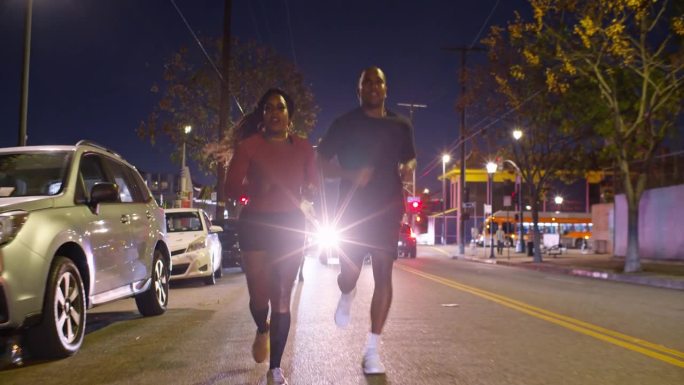 一对非裔美国夫妇在洛杉矶街头奔跑，朋友跟在后面