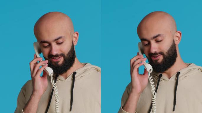 垂直视频穆斯林成年人在演播室用固定电话接听电话
