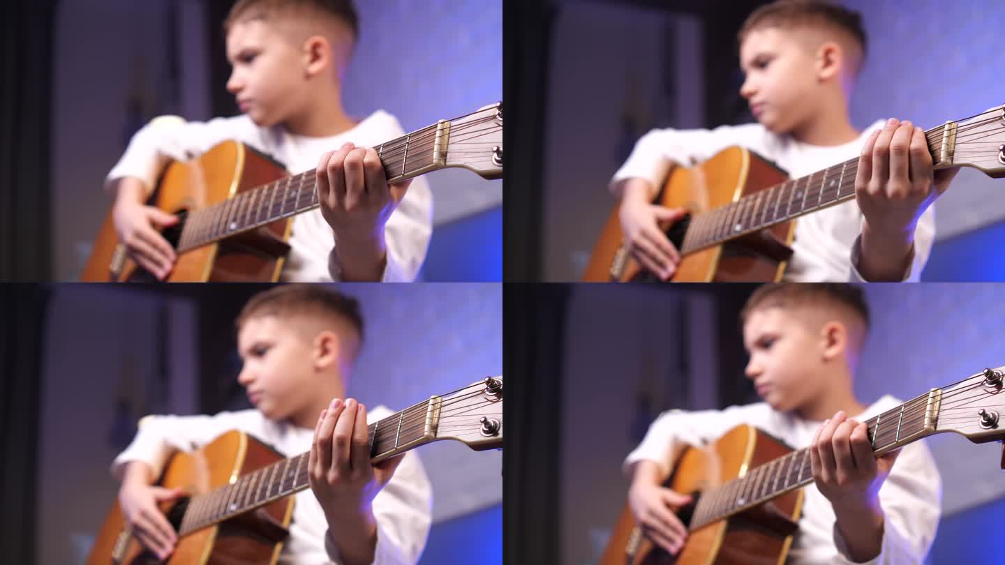专心紧张的小男孩在学习吉他、乐器