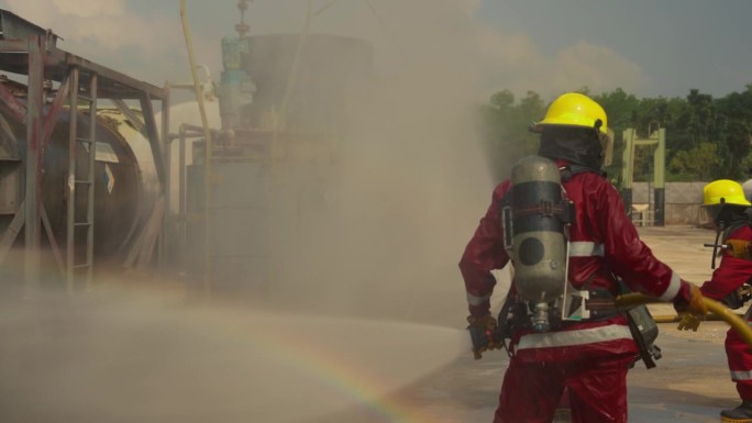 由5名不同年龄的男女组成的消防训练队穿着红色的安全服，戴着安全帽和氧气罐。