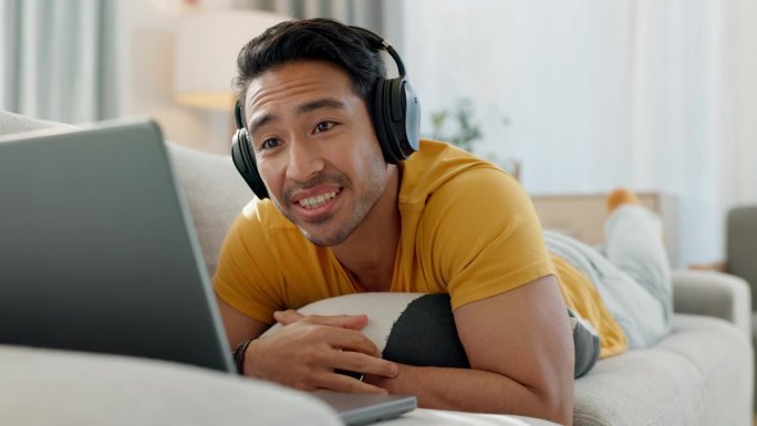 视频通话，笔记本电脑，和一个男人在他家客厅的沙发上飞吻，为了爱或浪漫。电脑、虚拟约会和一个戴着耳机在