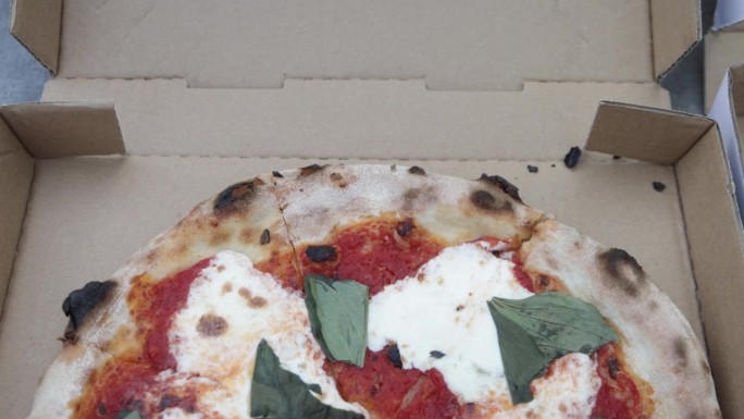 亚利桑那州凤凰城比安科披萨店的外卖盒里装着煮熟的玛格丽特披萨，视频向下倾斜。