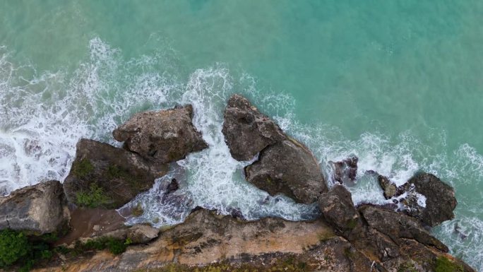 沿海热带岛屿上的巨大巨石被海洋中汹涌的冬季巨浪轰击，无人机自上而下