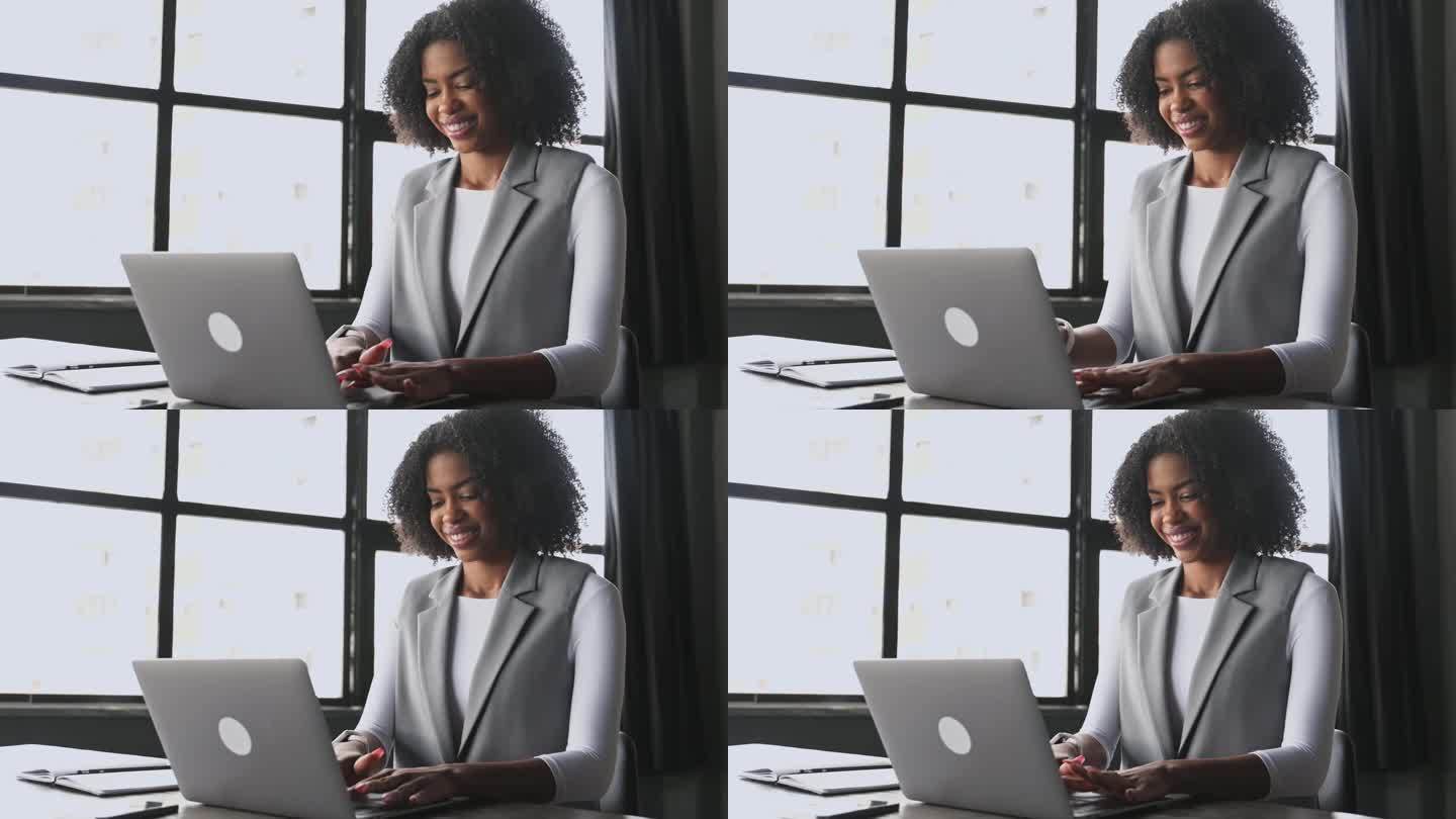 在一间光线充足的办公室里，这位女商人在笔记本电脑上打字，脸上带着满足的微笑