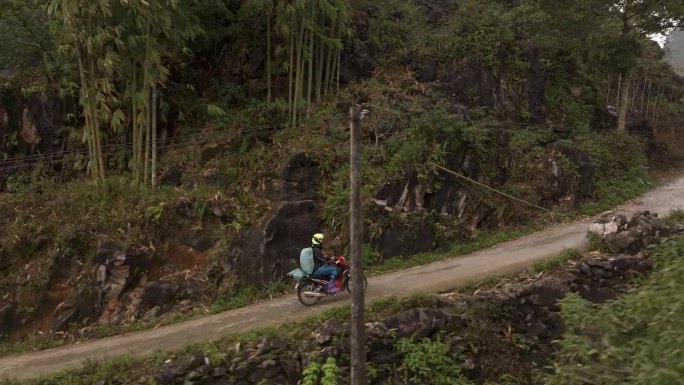 越南一辆上坡行驶的摩托车的侧面中近距离拍摄。