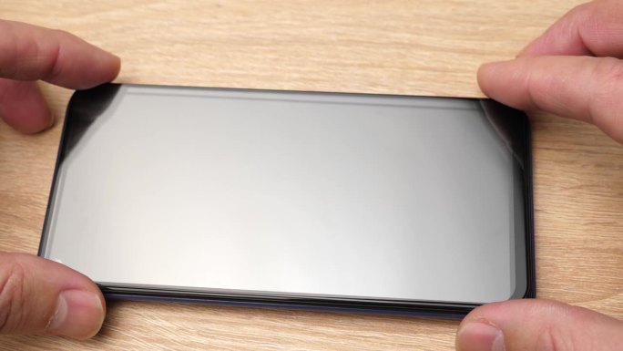 新的保护玻璃贴在智能手机的显示屏上。移动通信业务。