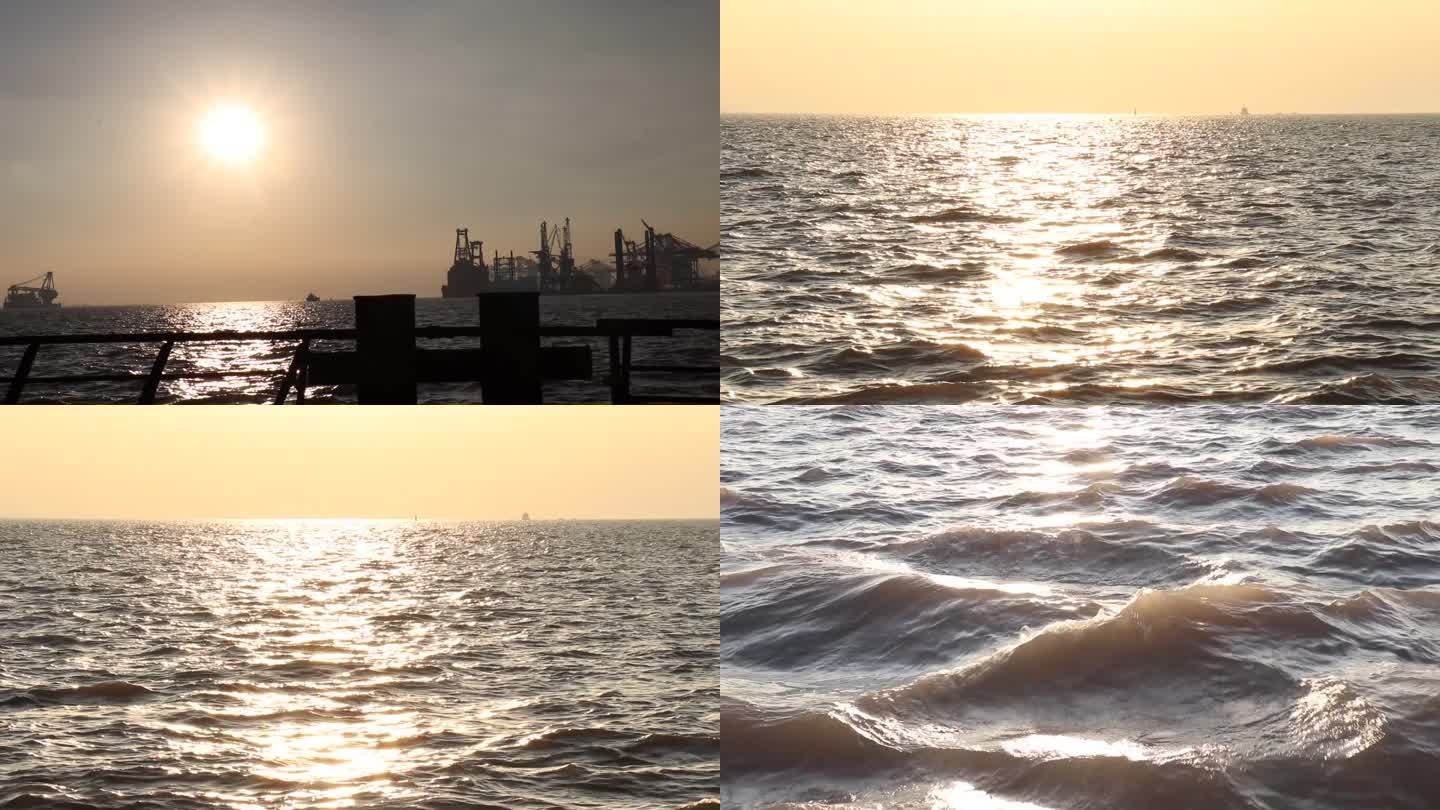 黄昏海边夕阳西下水面波光粼粼远处船舶烟囱