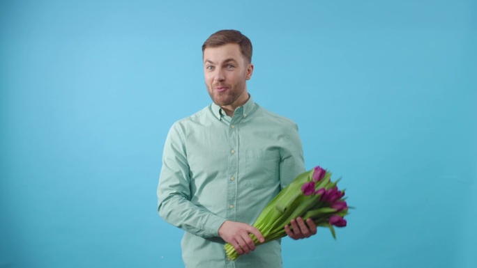 一个男人拿着一束蓝色背景的花跳舞