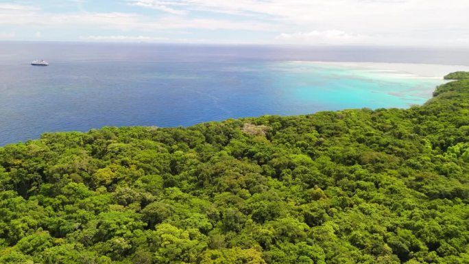 电影般的无人机在斐济的森林上空飞行，背景是游轮