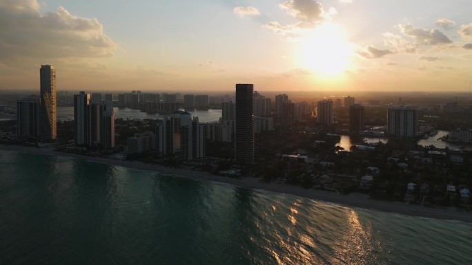 鸟瞰阳光岛和金色海滩在佛罗里达州的全景白色沙滩，清澈的海水和郁郁葱葱的绿色。高楼大厦从海岸拔地而起