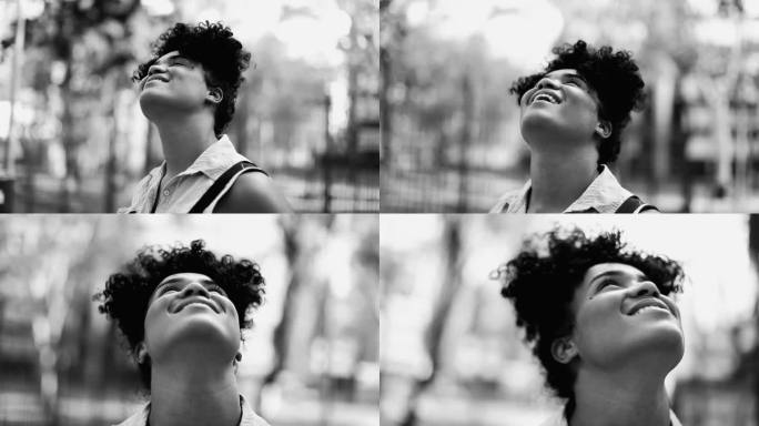 一位快乐沉思的巴西女性，20多岁，非洲裔，凝视着天空，黑白分明。单色肖像跟踪拍摄