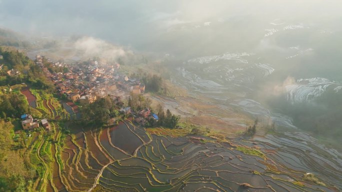 鸟瞰图，传统的哈尼族村庄周围的梯田在云南日落