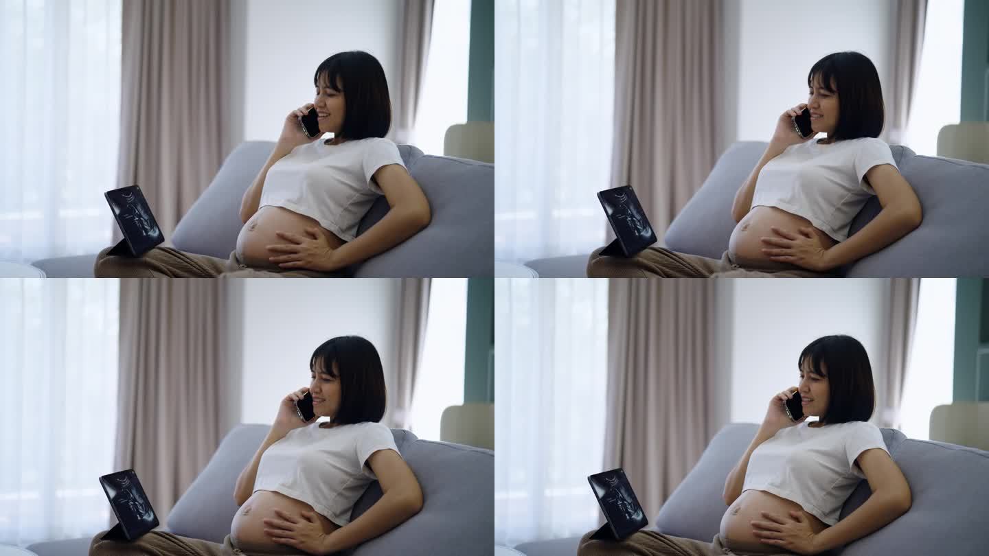 年轻的怀孕母亲高兴地看着平板上的超声波片，一边打电话给医生。