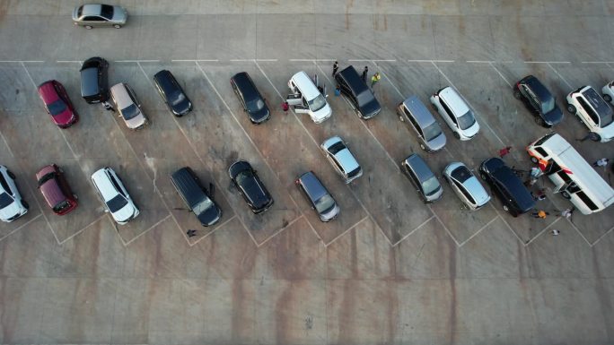 空中录像停车场。人员和车辆的交通。汽车停得整齐有序。