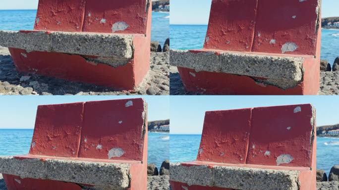 沙滩上的垃圾石凳，红漆正在脱落