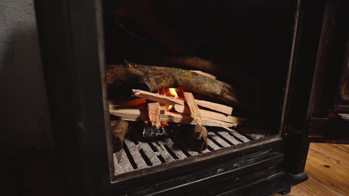 乡村家庭活动室里的壁炉。有火焰的木质火炉，门是敞开的