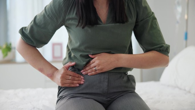 疼痛，月经和女人的手与胃痛，子宫内膜异位症或多囊卵巢综合征的健康问题在床上。腹部，阑尾炎或消化问题的