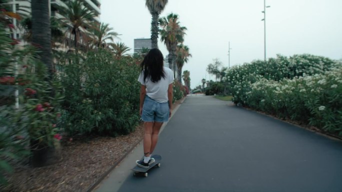 酷酷的千禧一代女性在海滩玩滑板