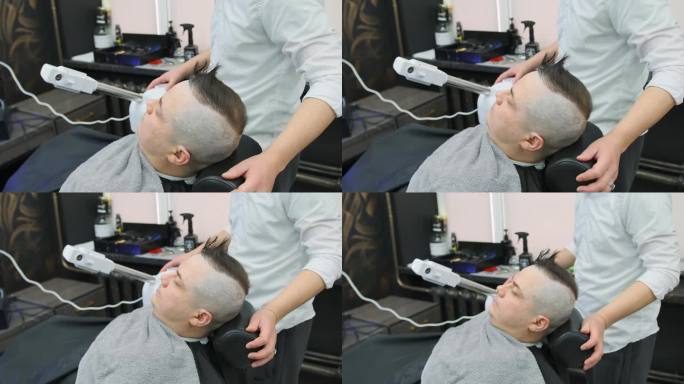 理发师让顾客靠近蒸汽加湿器，让他在剃须前做好准备