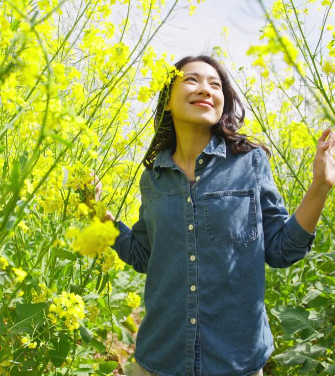 美女在盛开的油菜花海里心情舒畅享受春天