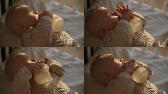SLO MO滋养的爱:婴儿男孩在日落时从瓶子里吃东西