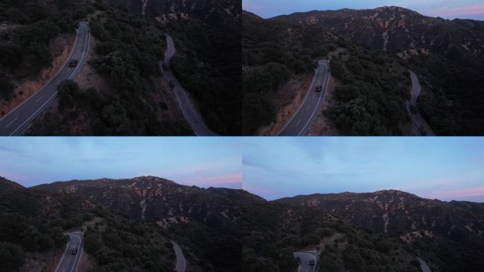 日落时分，黑色汽车沿着山口行驶，沿着山腰公路行驶