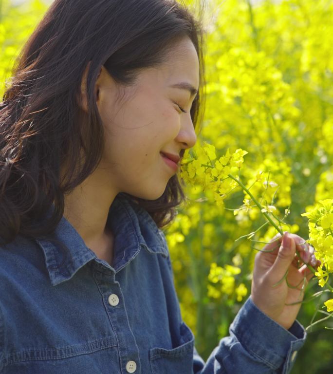 美女在盛开的油菜花海里心情舒畅享受春天