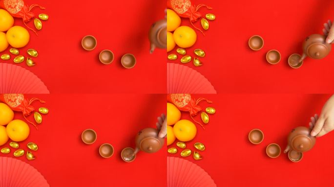 手持式茶壶，将茶倒入茶杯中，有中国农历新年的装饰