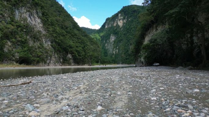 多明尼加共和国，穆夏斯阿瓜斯河岸上空低空飞行，背景是放松的人们。空中向前