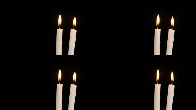 两支蜡烛在黑色背景上燃烧和熄灭，复制空间