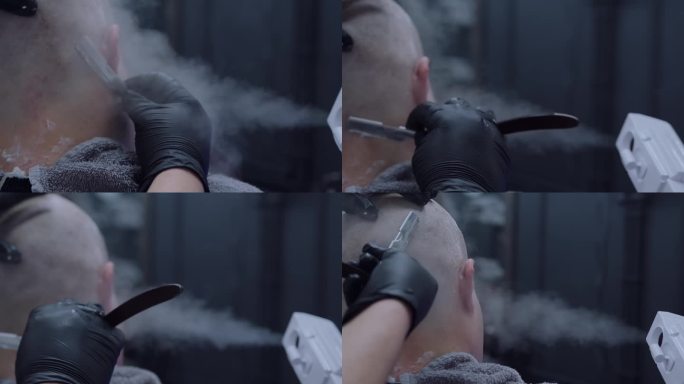 理发师的手在热蒸汽下用直剃刀剃头。