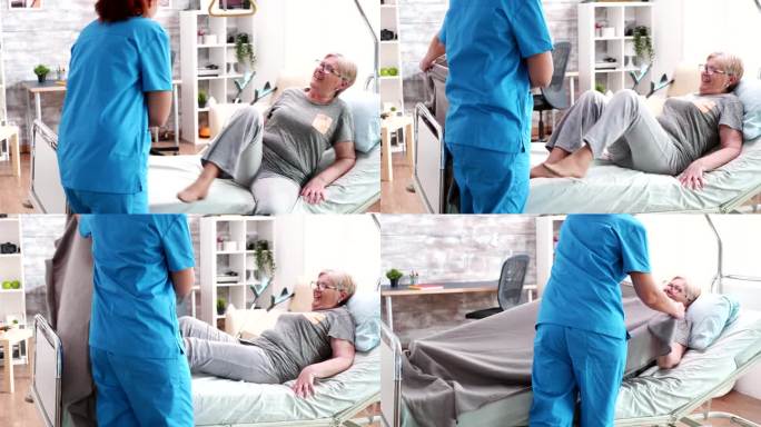护理院的女护士用毯子盖住老妇人