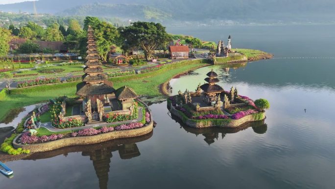 宏伟的Pura Ulun Danu寺庙在印度尼西亚巴厘岛的Bratan湖上装饰着鲜花。日出时在Pur