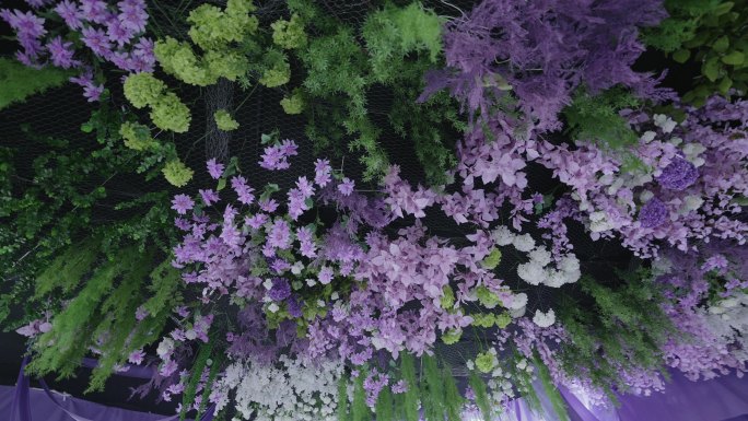 紫色和绿色搭配的婚礼吊顶手捧花与拉起的手