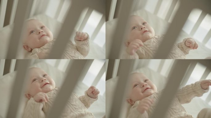 《一瞥奇迹》:小男孩可爱的咯咯笑和快乐的向上凝视，在婴儿床舒适的拥抱中被看不见的奇迹所吸引