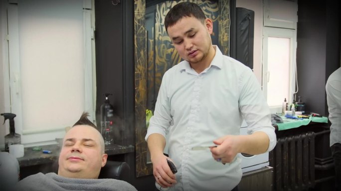 美发师在顾客面前用酒精点燃剃刀消毒。