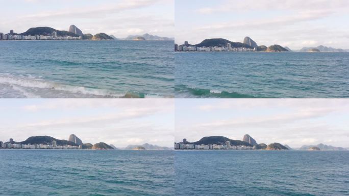 白天，里约热内卢的科帕卡巴纳海滩风景如画，对面是甜面包山