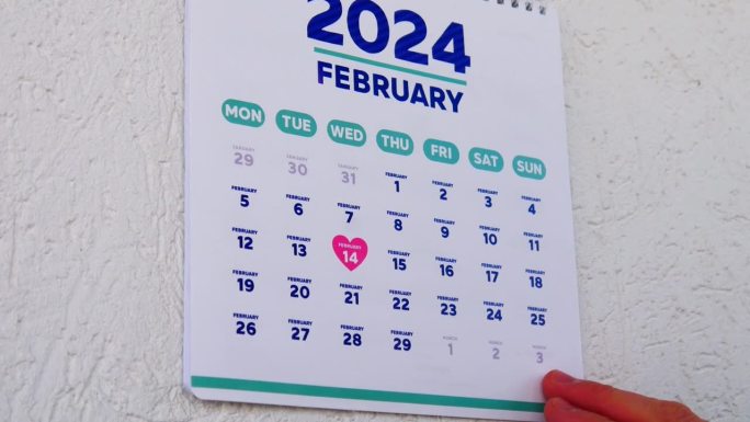 特写:两只男性的手撕下了墙上日历2024年1月的一页，紧接着撕下一页上写着情人节的日期