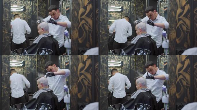 理发店里的理发师用直剃刀用肥皂泡沫给一个男人剃头。