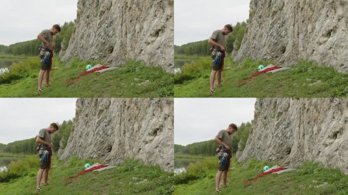 一名男子在岩石底部穿上攀岩装备