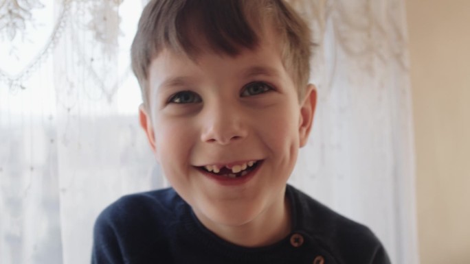 可爱的小男孩笑着乳白色的牙缝