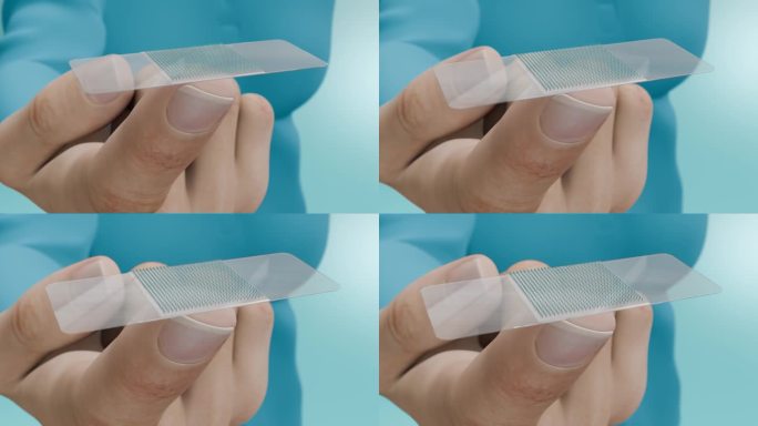 一只手用微针捏着皮肤贴片的特写。透皮疫苗:一种使用皮肤贴片和微针的新方法。3 d动画。