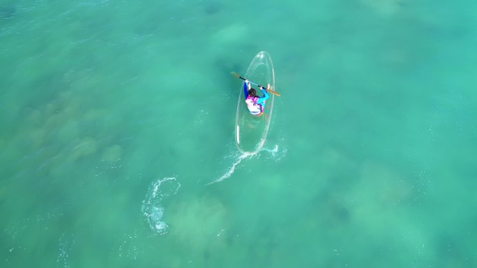 海南三亚高视角牛奶海上正体验玻璃船的游客