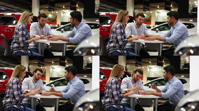 一对幸福的夫妇在经销商处签署购车文件，看起来非常兴奋